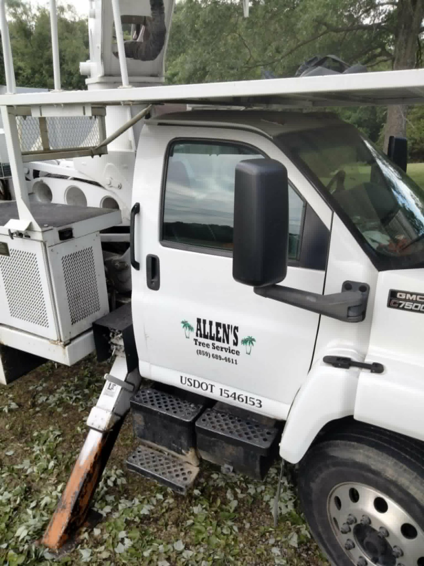 Close-up of the Allen's Tree Service door logo on the GMC bucket truck